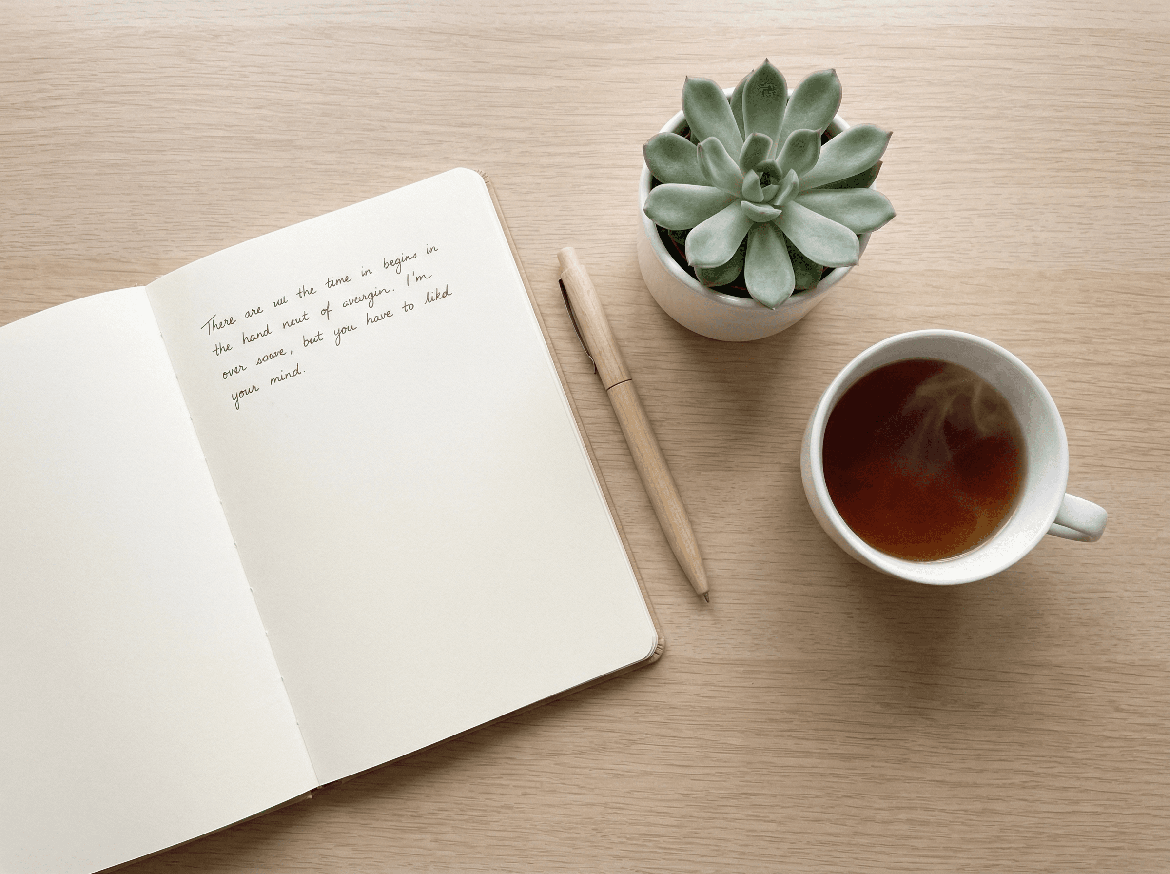Notizbuch, Tee und Pflanze – ruhige Arbeitsatmosphäre